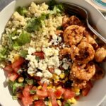 Chili-lime shrimp bowl with cilantro-lime quinoa, bean-corn pico de gallo, avocado, and creamy chipotle ranch served in a bright, colorful bowl.