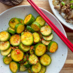 Crunchy Korean spicy cucumber salad (oi muchim) made with gochugaru, sesame oil, and scallions served in a bowl.