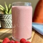 Low glycemic raspberry protein smoothie made with Greek yogurt, hemp seeds, and flax, served in a glass with a vibrant pink color