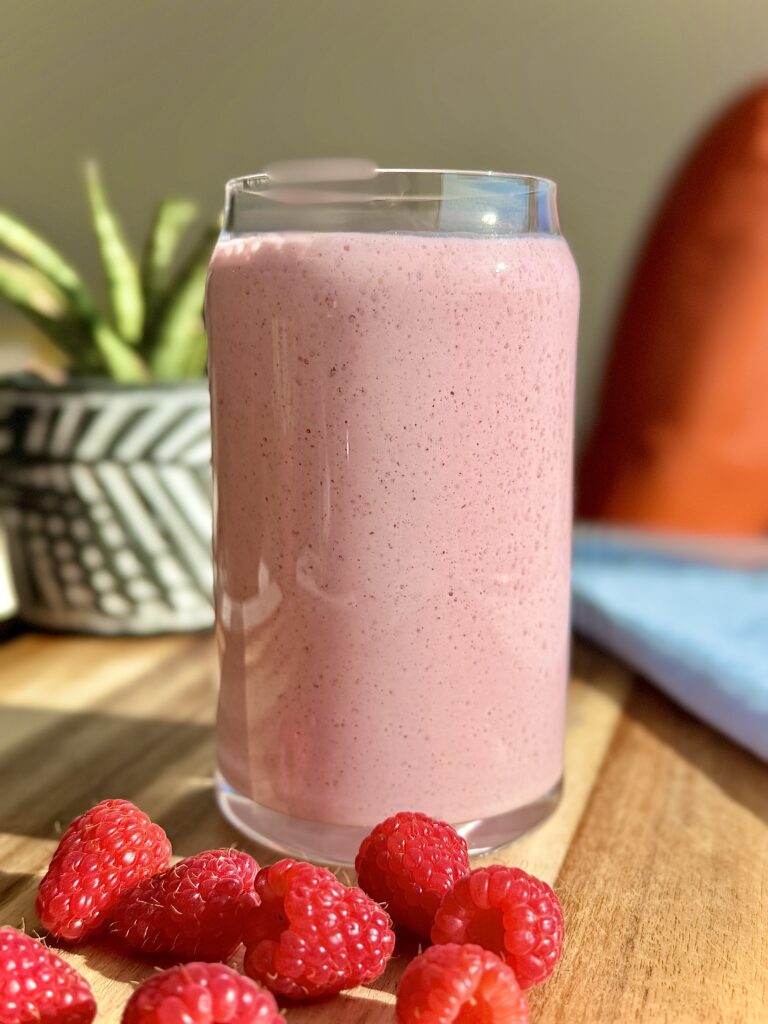 Low glycemic raspberry protein smoothie made with Greek yogurt, hemp seeds, and flax, served in a glass with a vibrant pink color